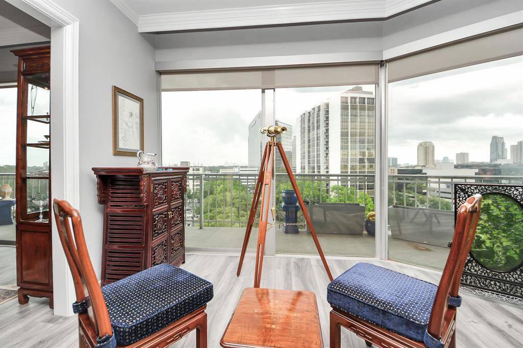 This bright room features expansive floor-to-ceiling windows with city views, creating a serene space perfect for relaxation or entertaining. Complemented by a balcony that extends the living area outdoors.