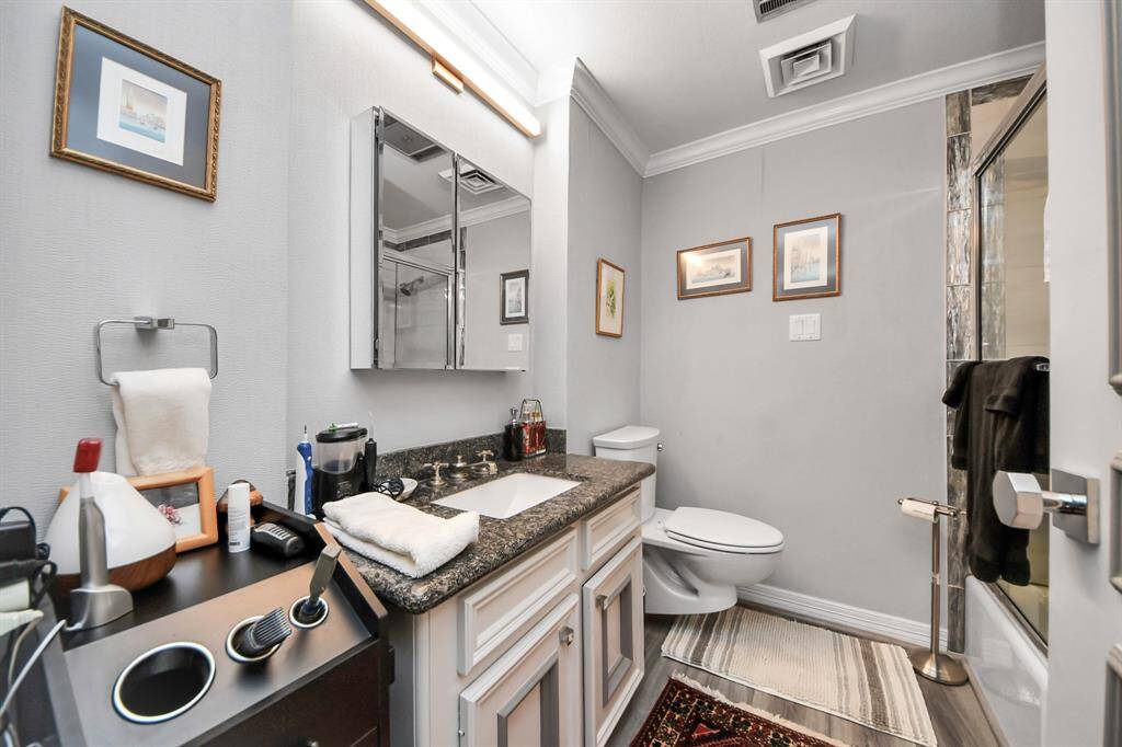 Full bath has and enclosed shower. The space is accented with framed artwork and has a neutral color palette, creating a clean and inviting atmosphere.