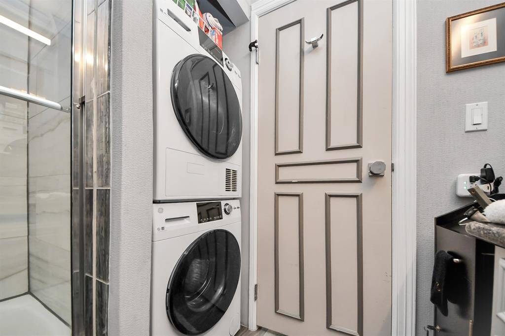 Compact laundry area with a stacked washer and dryer.