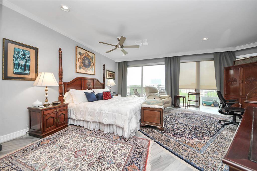 Spacious primary suite large windows and balcony view.
