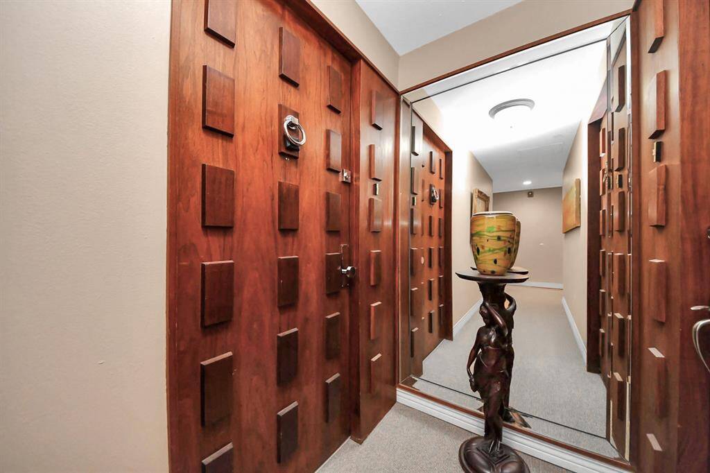 Welcome home! The front entrance features distinctive wooden doors with geometric designs. An elegant ENTERYWAY!