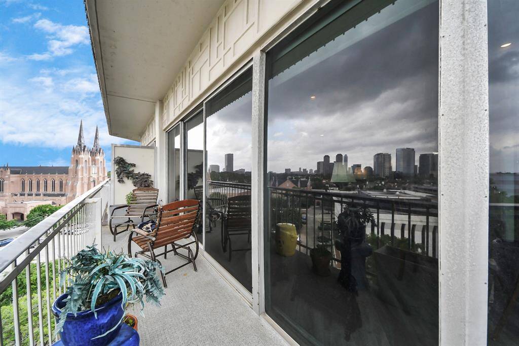 Spacious balcony with city skyline views, featuring ample space for outdoor seating and decor. Perfect for enjoying the urban landscape and entertaining.