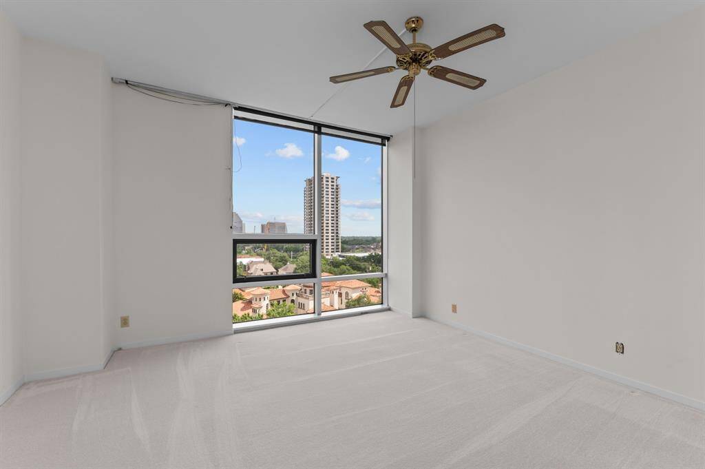 Bright, spacious room with large windows offering a scenic view. Features include a built-in wet bar with granite countertop and ample natural light. Perfect for entertaining or relaxation.
