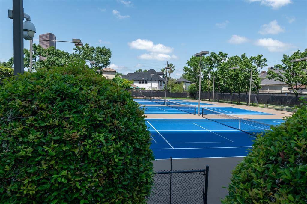 A serene outdoor pool area surrounded by lush greenery, with the secondary condo building nearby. Ideal for relaxation and outdoor enjoyment.