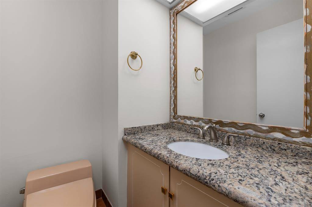 This elegant front entrance room features a modern, well-lit reception area with sleek, gray paneling and a stylish ceiling design. Large windows provide natural light, while a plush area rug and tasteful decor enhance the inviting atmosphere.