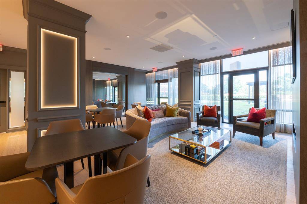 This spacious and stylish living area features modern furnishings, large windows for natural light, and a cozy seating arrangement perfect for relaxation and entertainment.