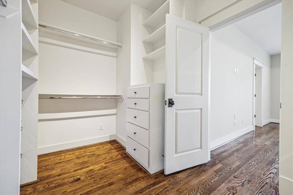 Large primary bedroom closet space with built in cabinet.