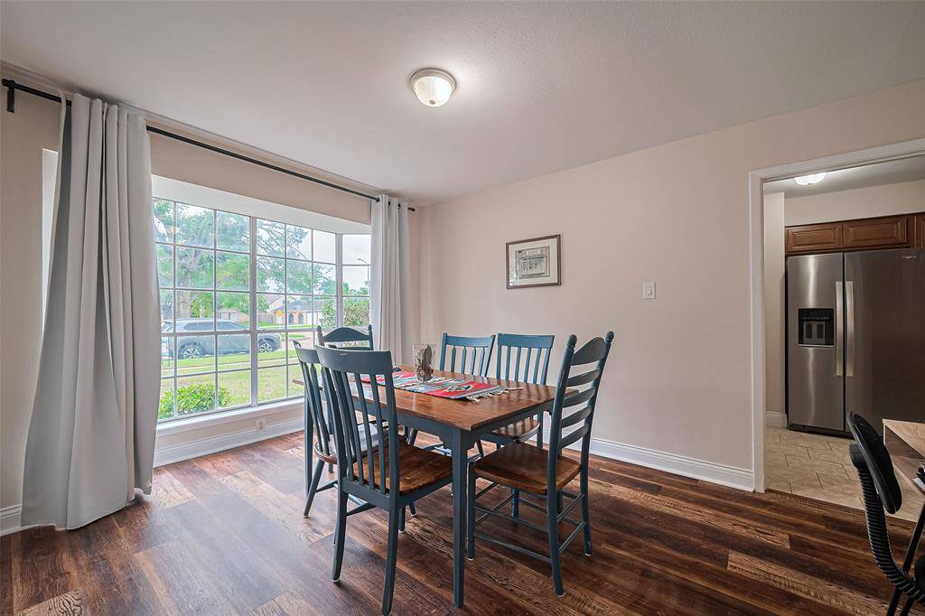 The formal dining room open to the entrance and kitchen with a beautiful view of the front yard.