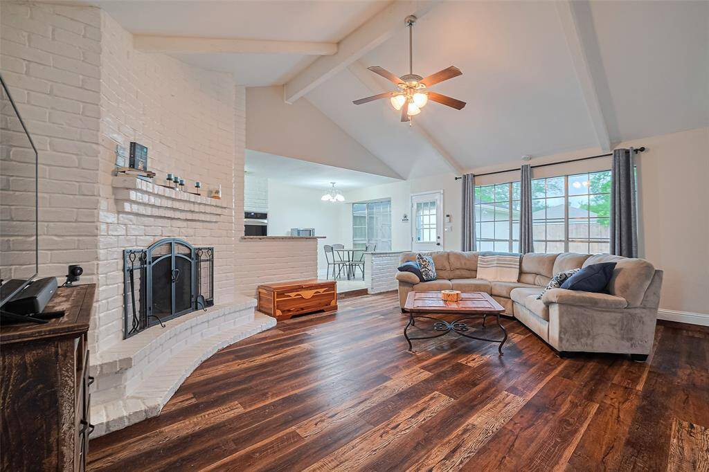 Living room with wood burning fire place, open to the kitchen and breakfast nook.