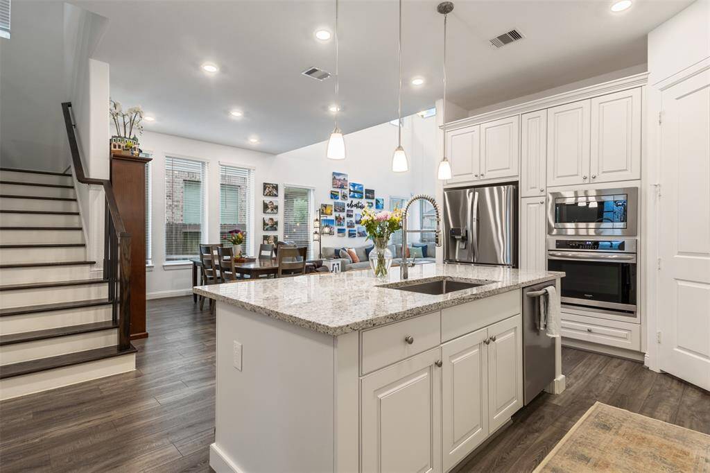 The kitchen is open and airy flowing into the dining area, entry, living space and stairs to second floor.
