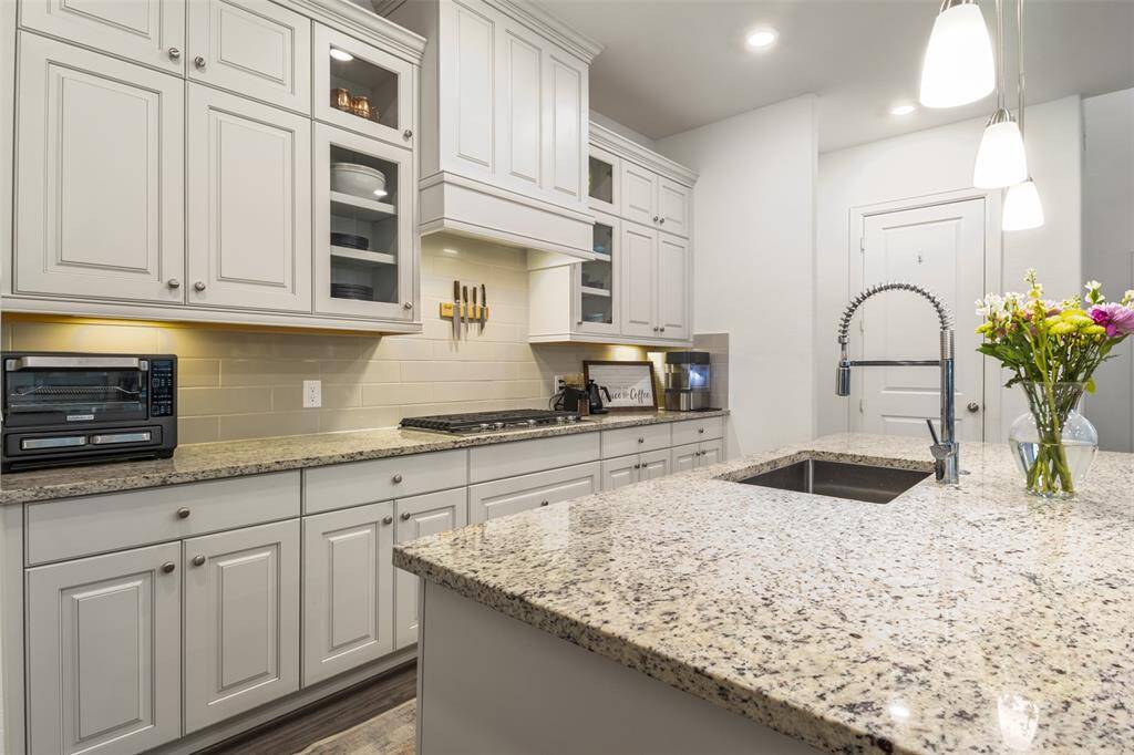 gorgeous granite countertops and white cabinetry all the way up to the ceilings give this bright kitchen a luxury feel and welcoming atmosphere!