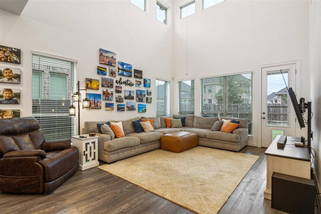Bright and spacious living room with high ceilings, large windows, Ideal for family gatherings and relaxation.