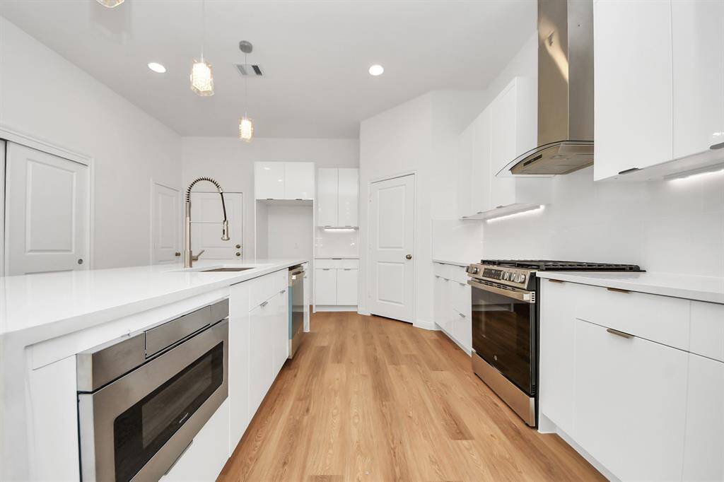 The kitchen is equipped with stainless steel appliances including a dishwasher, microwave, and stove.