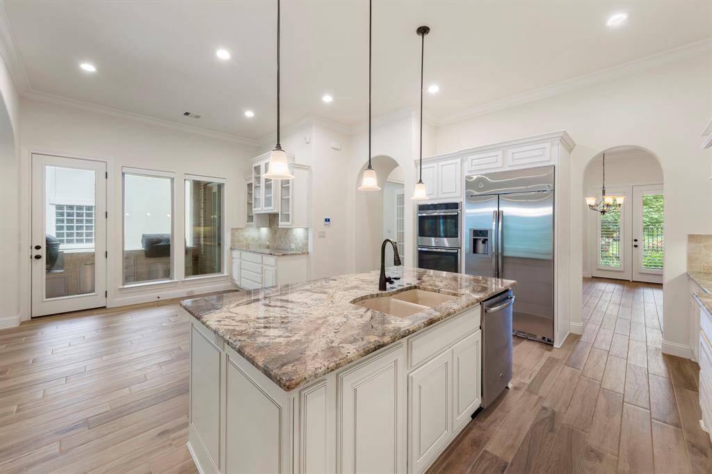With direct access to the outdoor kitchen and views of the lush backyard, this open-concept kitchen seamlessly connects indoor elegance with alfresco entertaining.