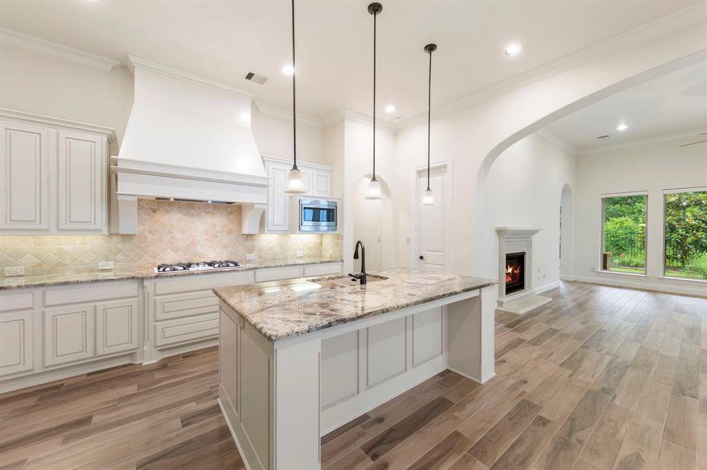 The heart of the home, this open kitchen flows effortlessly into the living area, where a cozy fireplace and expansive windows invite you to relax with views of the lush nature preserve beyond.