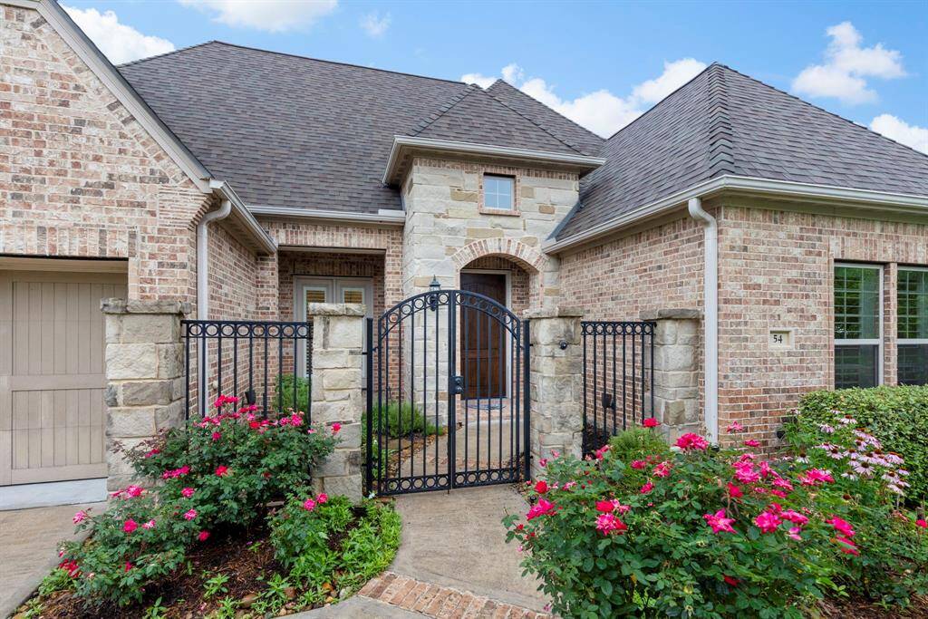 A charming gated courtyard entry welcomes you with blooming roses and timeless stone and brick architecture, setting the tone for luxury and privacy.
