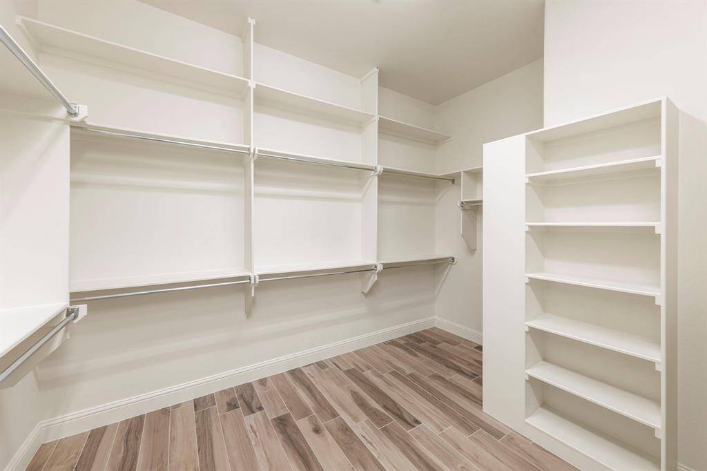 The expansive walk-in closet is thoughtfully designed with shelving, double hanging rods, and built-in storage—offering a functional and elegant space to stay effortlessly organized.