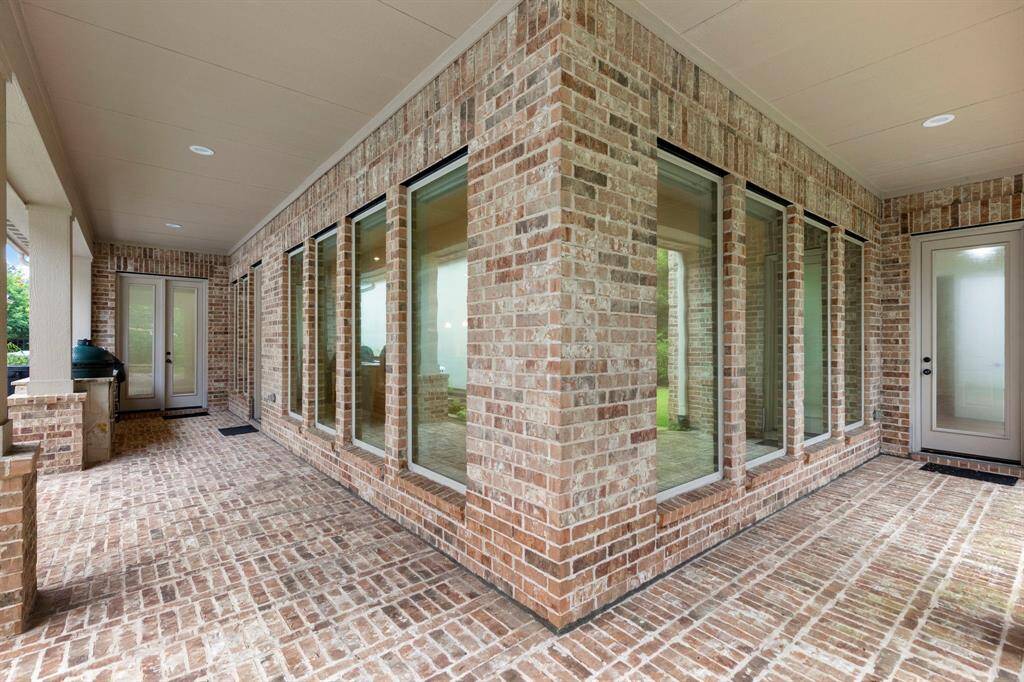 Wrapped in timeless brick and lined with floor-to-ceiling windows, the expansive covered patio offers seamless indoor-outdoor living and year-round entertaining.