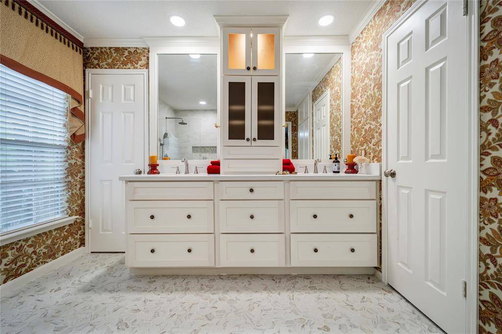 Custom cabinets with dual sinks and quartz countertops. All closets in this home are outfitted with Elfa shelving and drawers.