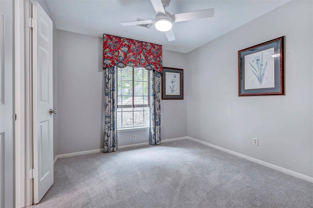 Upstairs third bedroom featuring elegant custom curtains and plush carpet for a cozy retreat.