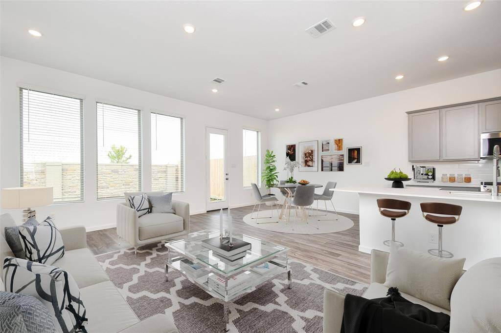 Open floor plan with tons of natural light! A view of the family room. Virtually staged photo