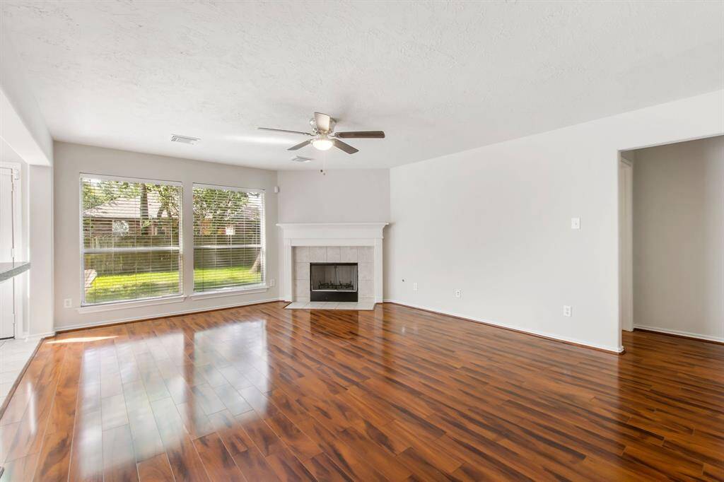 The den offers a wall of windows, a wood burning fireplace with gas starter, and laminate wood floors. So much natural light!