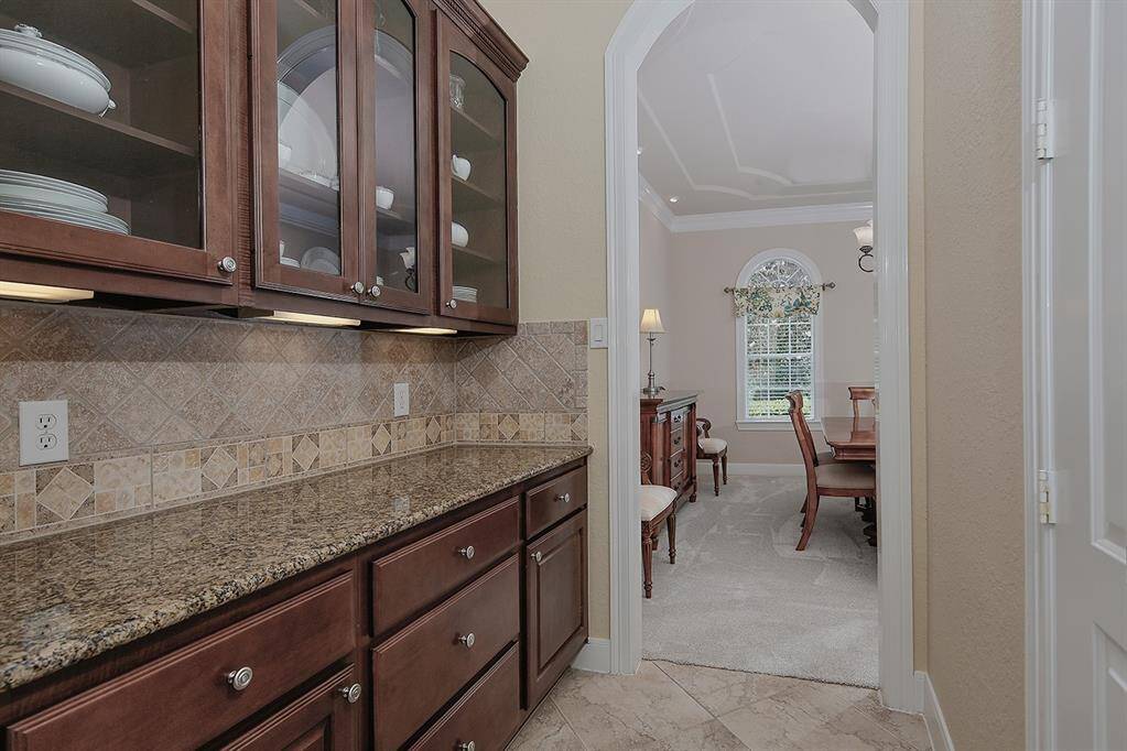 The butlers pantry has extra counter space to serve buffet-style. Glass front upper cabinets are perfect to display stemware and special dishes for entertaining.