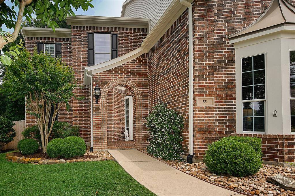 The inviting arched entryway and well-maintained landscaping enhances home's curb appeal.