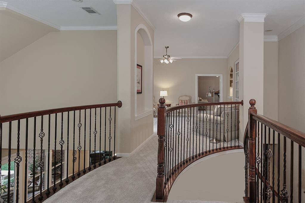 Wrought iron railings lead to the second floor game room.