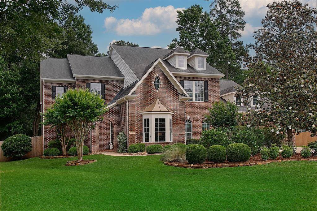 Architectural details add interest and charm to front elevation. Warm and welcoming brick tones, dormer windows, shutters, and bay window with metal roof give it style.