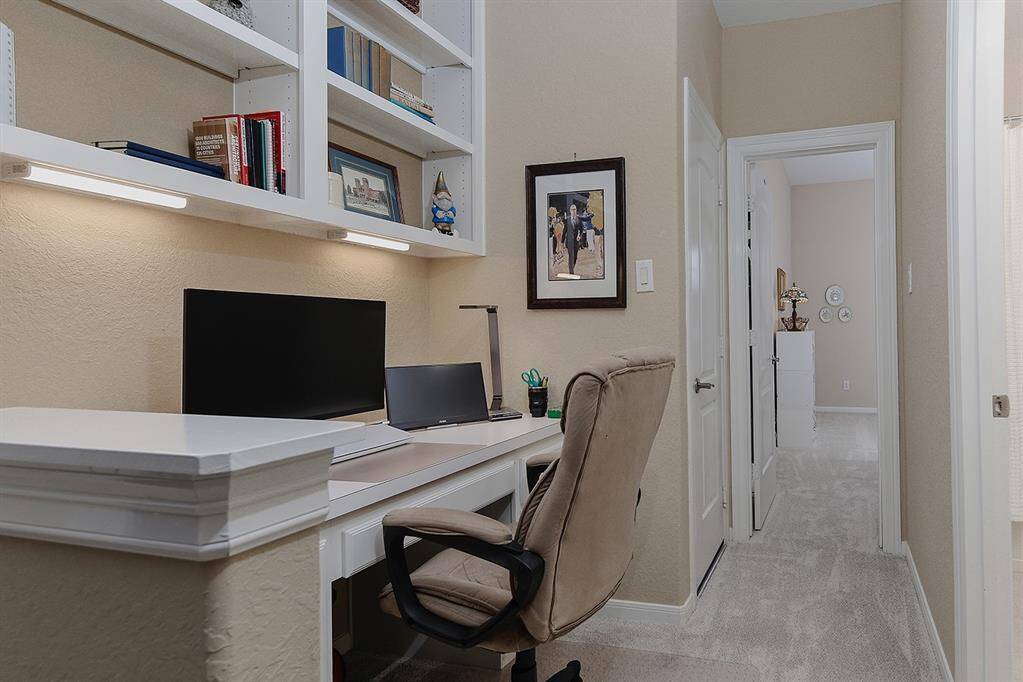 Great study nook off game room has built-in desk and shelves with ample work surface, storage, and lighting.