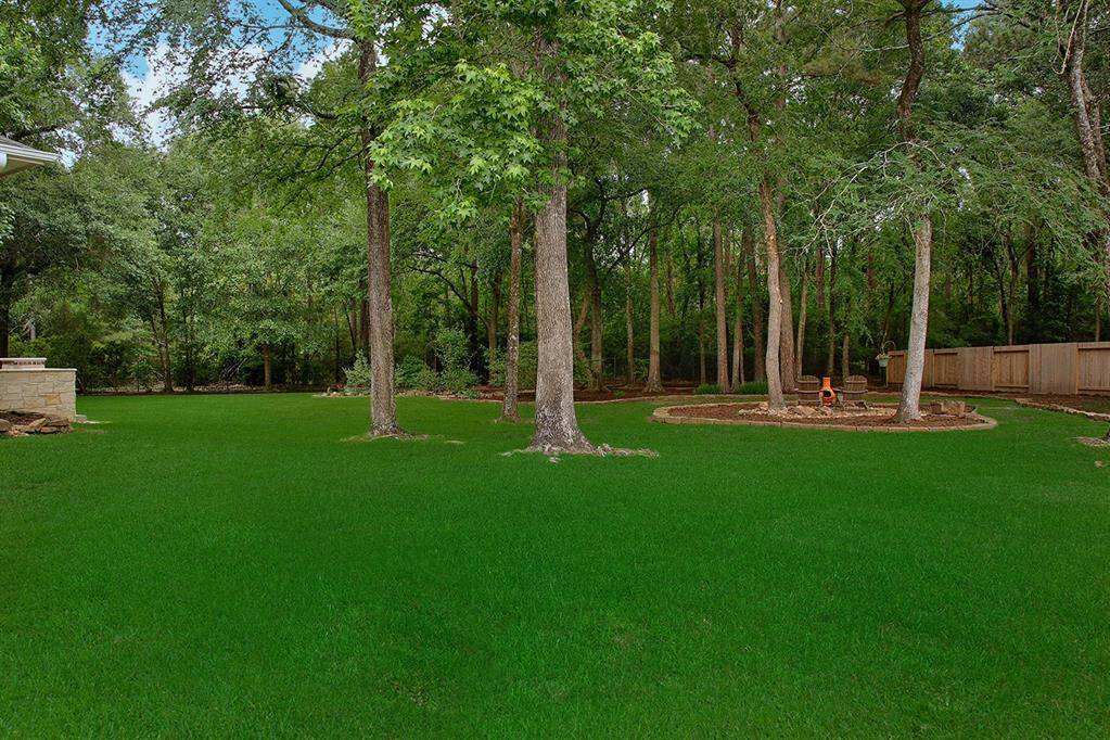 Sprawling lush green lawn is welcoming, same goes for chiminea spot tucked under trees.