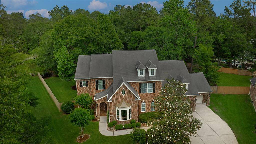 This beautiful two-story brick home features elegant architecture with dormer windows and a spacious driveway.