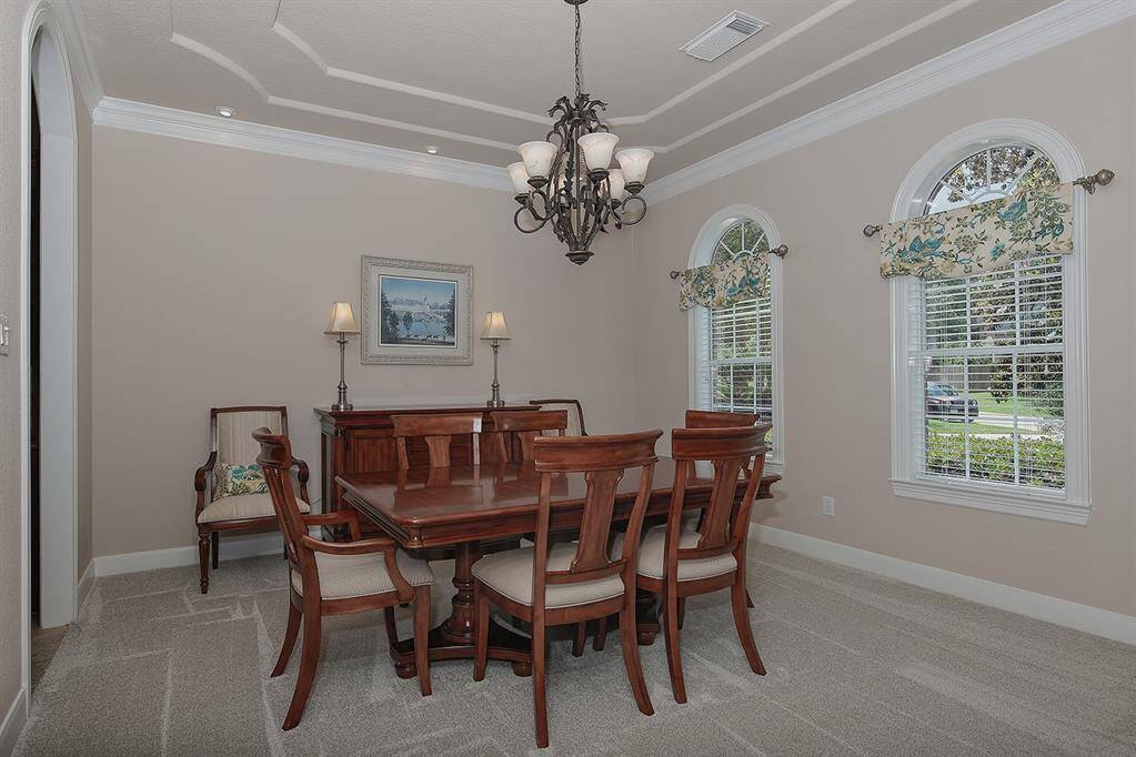The dining room features crown molding and large windows offering ample natural light.
