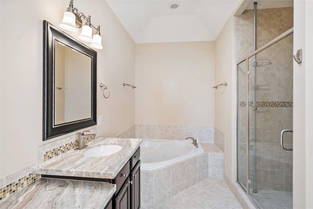 The primary bathroom has a jetted tub, standalone shower, and dual vanity with so much room for your grooming tools and products.