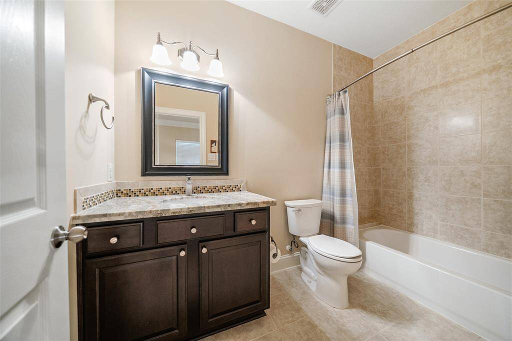 The shared bathroom in the hallways has an updated granite counter and sink, updated toilet, and features a shower/tub combo.