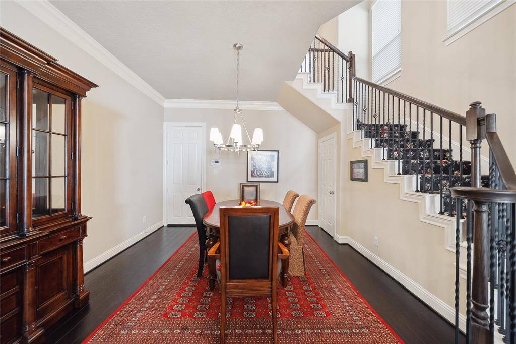 The dining room is to the right of the entrance and the kitchen. The entire downstairs features crown moulding and engineered wood floors. The dining room looks towards the kitchen, which is very open to the living room and outside. The flow for entertaining is perfect. To the right, under the stairs, is a storage closet. Directly ahead in this photo is access to the garage.