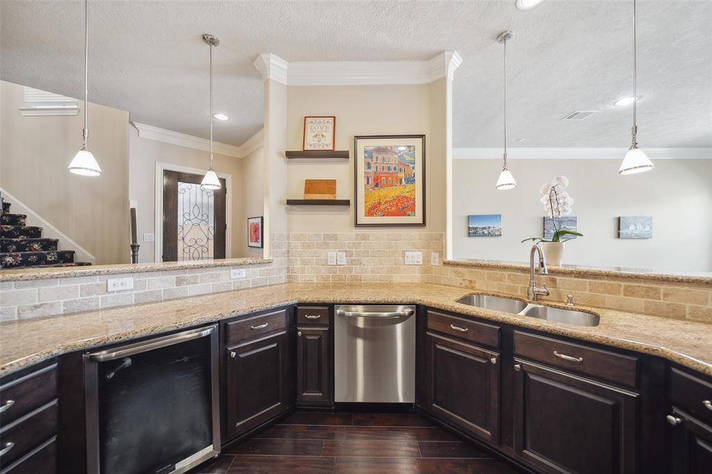 The kitchen features granite counters, chocolate cabinets, a full appliance package, and a wine fridge.
