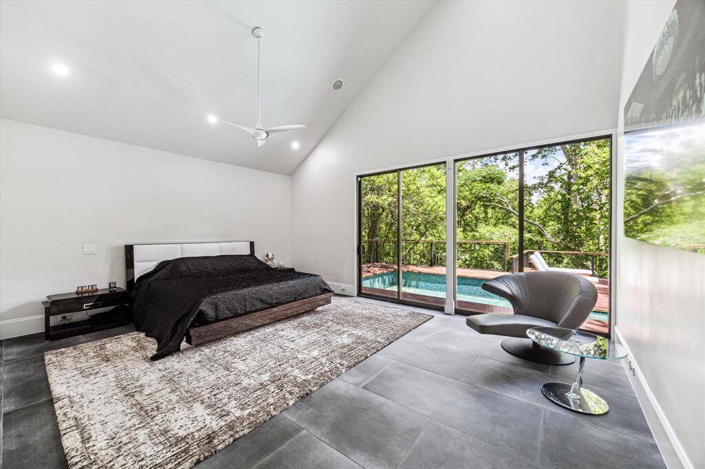 The combination of high ceilings and wide windows in the primary bedroom not only amplifies the sense of space and light but also connects the interior with the outside world, bringing nature and sunlight into the room. This harmonious blend of architectural elements and natural elements makes the bedroom a serene retreat and a perfect sanctuary for rest and rejuvenation.