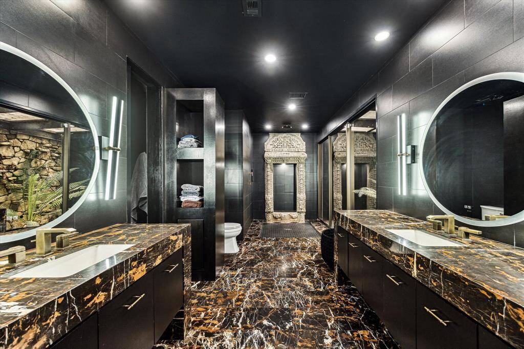 This stunning primary bathroom that not only boasts two separate vanity areas with their own sink and mirror, a large shower, but also includes a private atrium. This unique feature adds a touch of nature and tranquility to your daily routine.