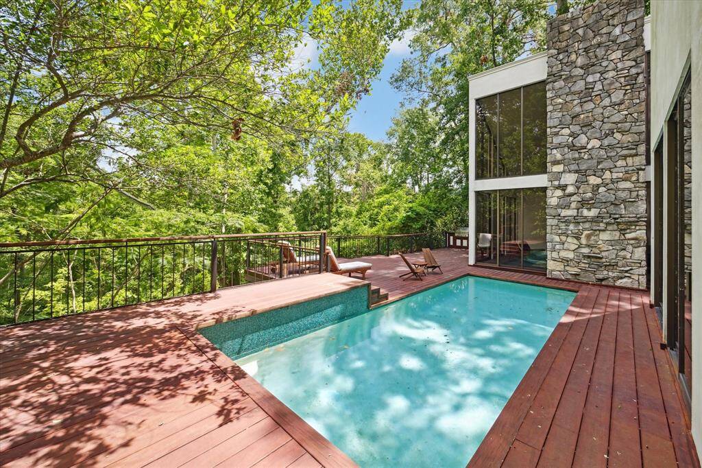 Imagine stepping out into a serene oasis where a glistening pool takes center stage, surrounded by a beautiful wooden deck that exudes warmth and elegance. The pool's crystal-clear waters invite you to take a refreshing dip on a sunny day, while the wooden deck provides a stylish setting for relaxation and entertainment.