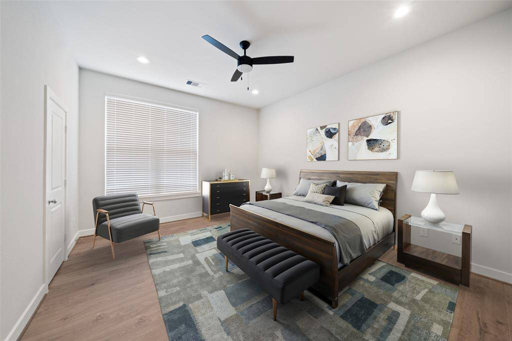 Primary bedroom with a large window providing natural light. Virtually staged.