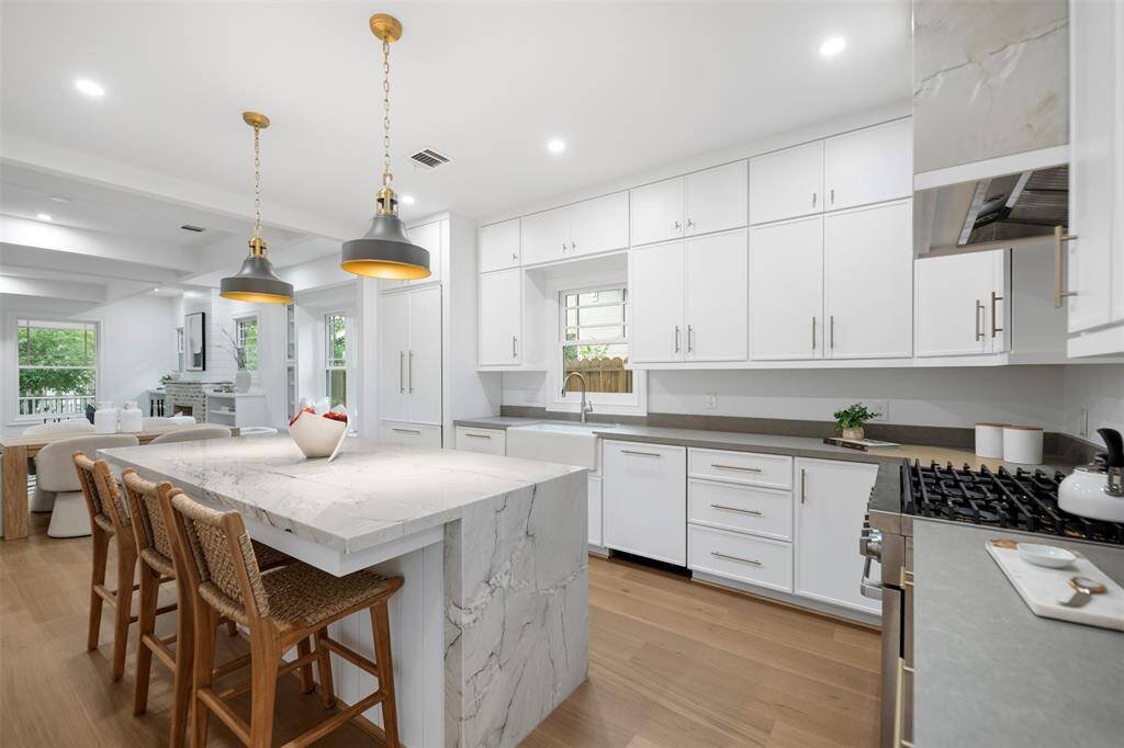 Kitchen features quartzite countertops and water fall island for easy entertaining