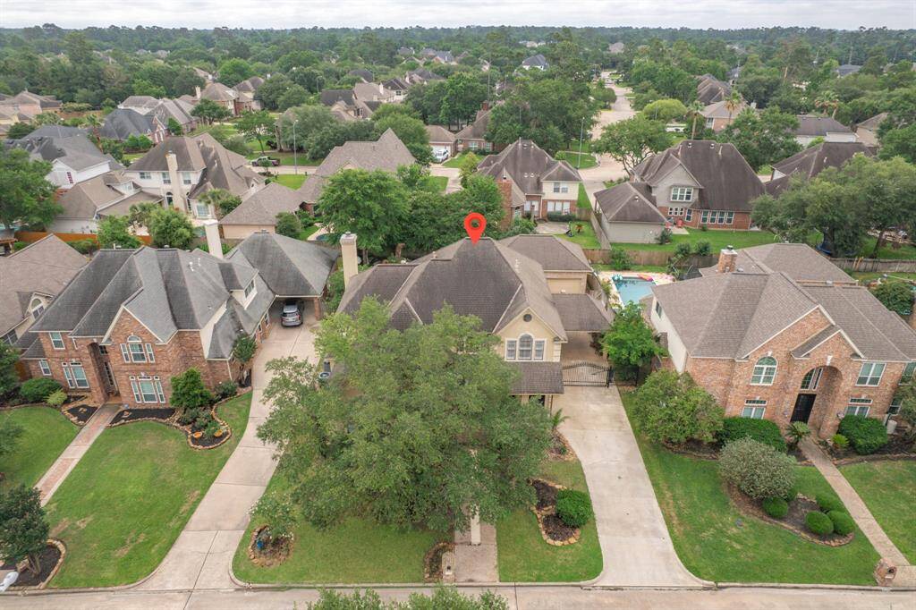 Charming suburban neighborhood with spacious homes and well-maintained yards. The highlighted property features a large driveway, mature trees, and a backyard pool, offering a blend of comfort and luxury.