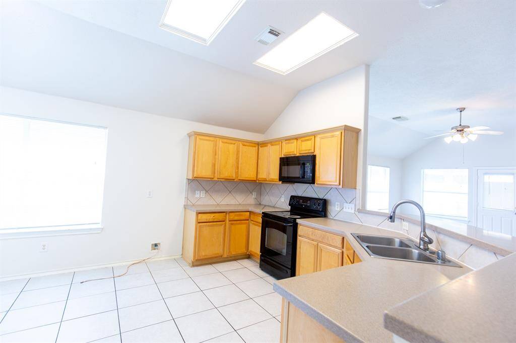 Bright kitchen with vaulted ceilings with plenty of cabinets and a spacious pantry.