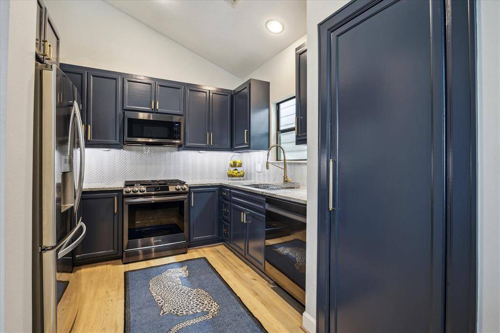 Kitchen with recent appliances and large pantry.