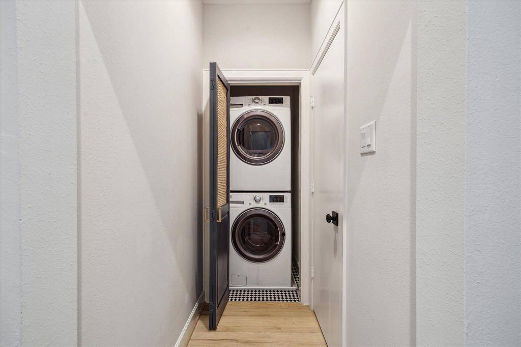 Utility closet with stacked washer/dryer and folding door.