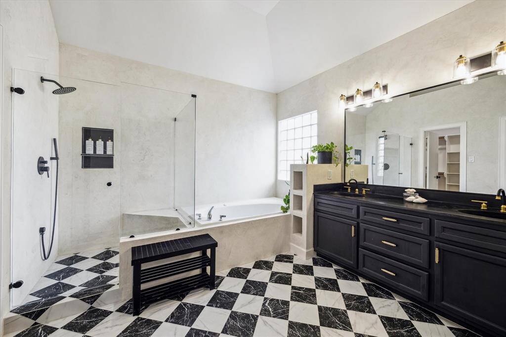Updated primary bath with double sinks and framless shower.