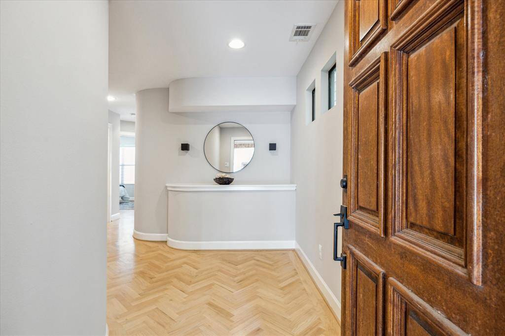 Entry with herringbone wood floors and built in credenza.