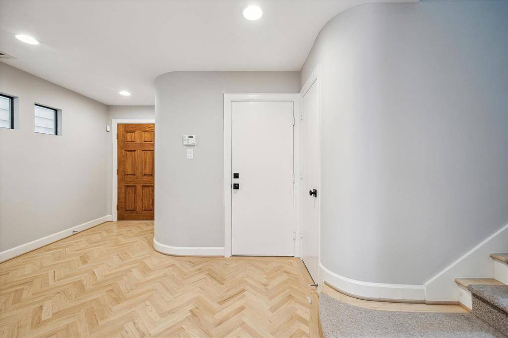 Entry looking towards garage entrance and large storage closet underneath the stairs.